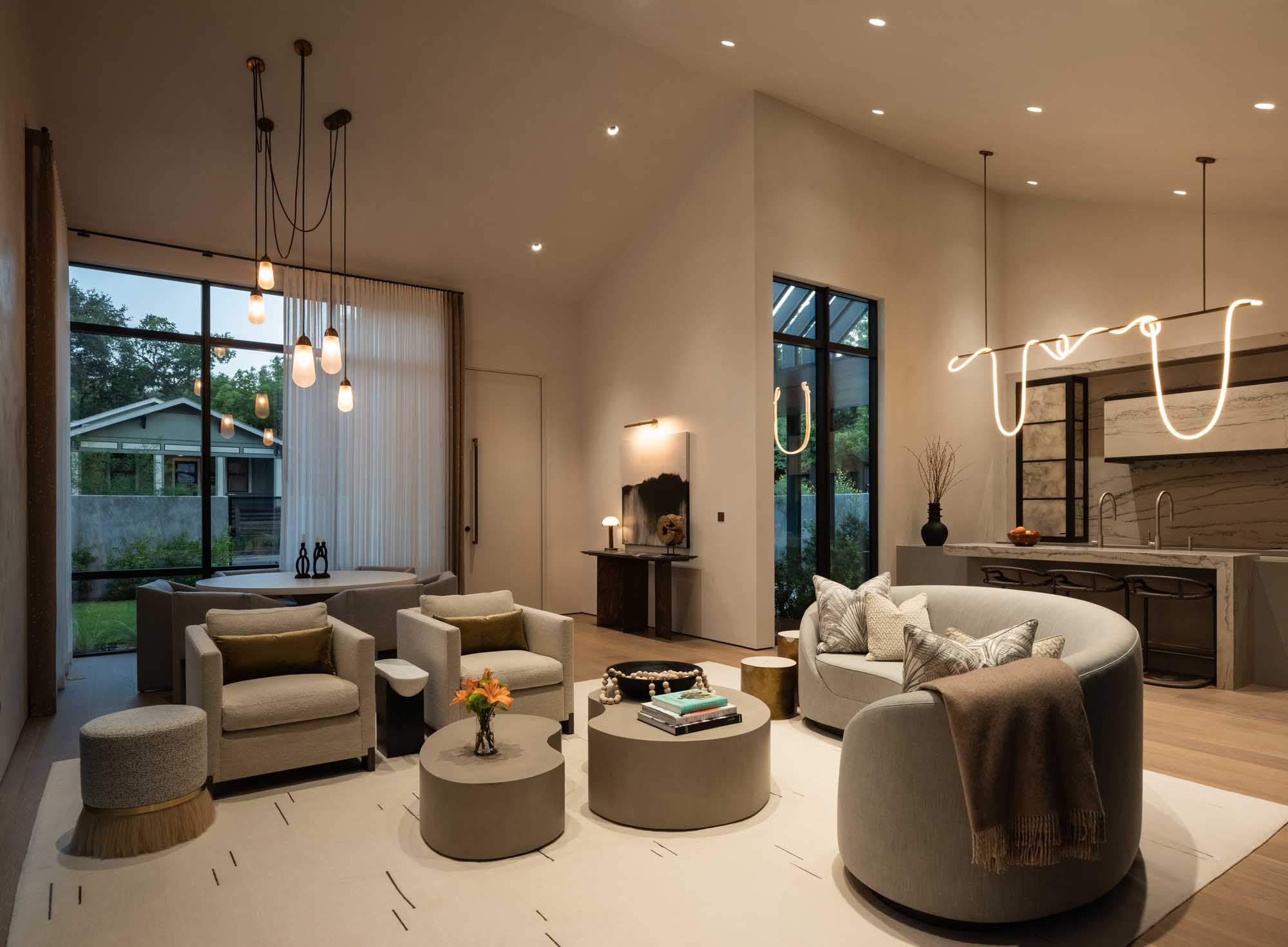 Luxury living room with warm mood lighting featuring a neon sculptural light and pendant lamps