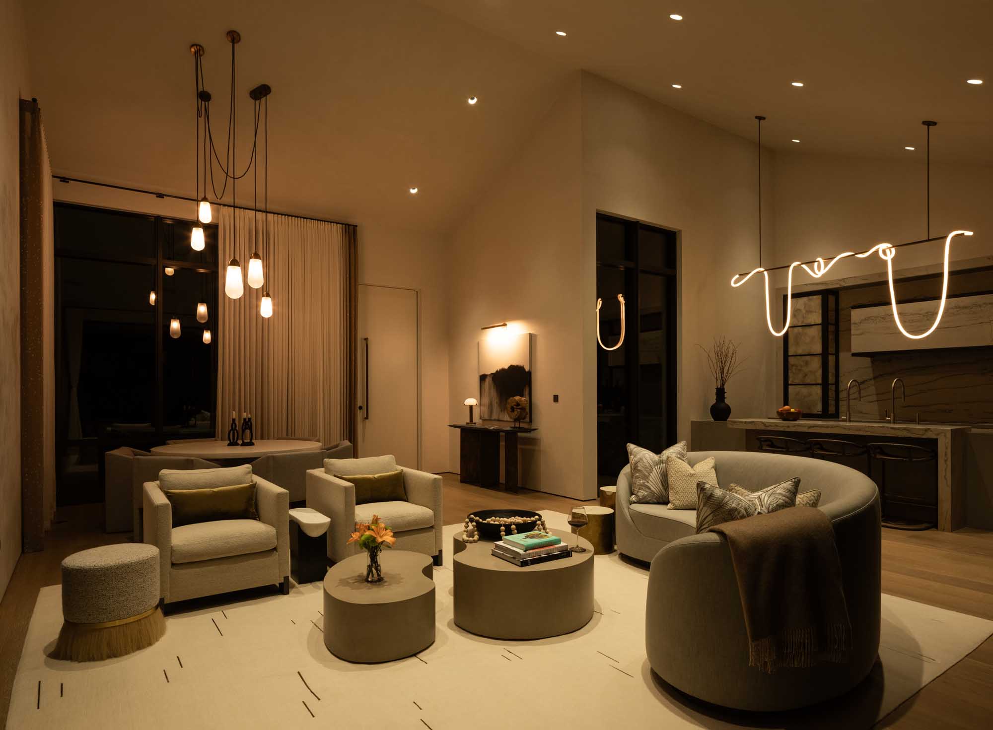 Luxury living room with warm mood lighting featuring a neon sculptural light and pendant lamps