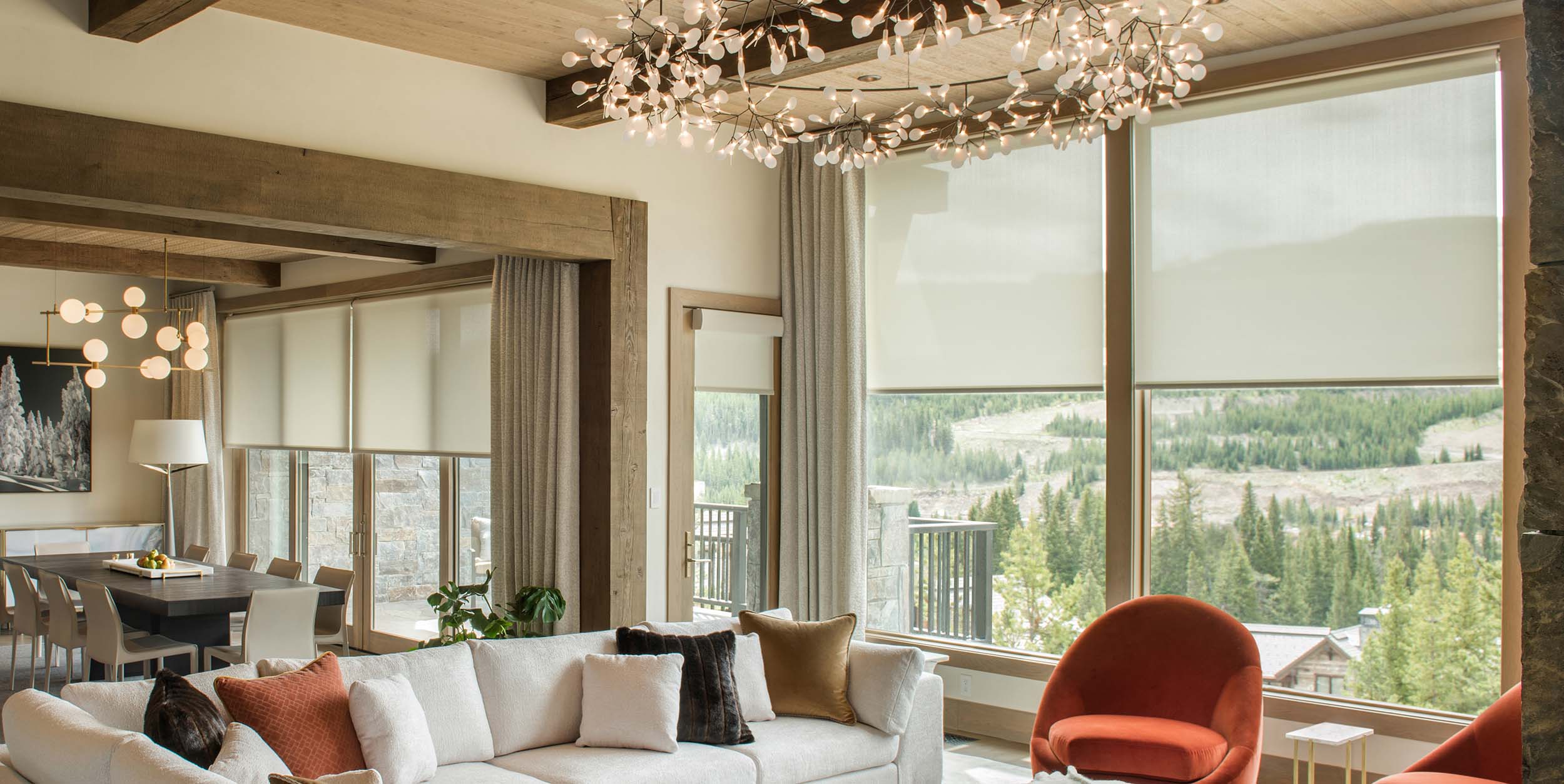 Open plan living area with motorized roller shades and decorative curtains