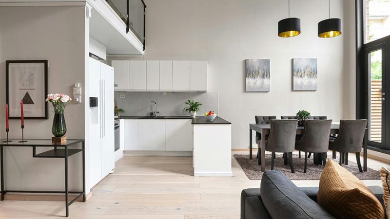 Modern open concept kitchen and dining area with minimalist white cabinetry