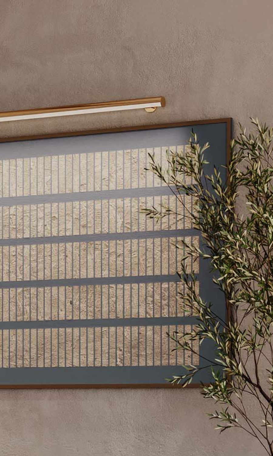 Minimalist framed artwork illuminated by a sleek gold picture light on a textured wall